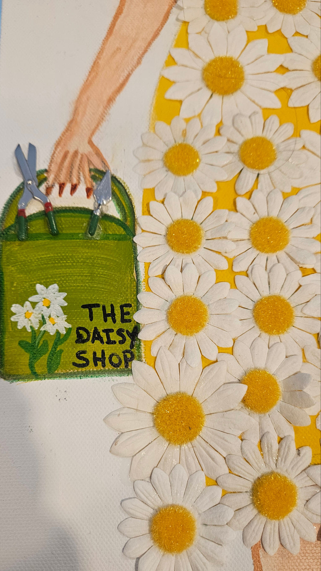 Floral design with a hand holding a green bag labeled 'The Daisy Shop' and white daisies.