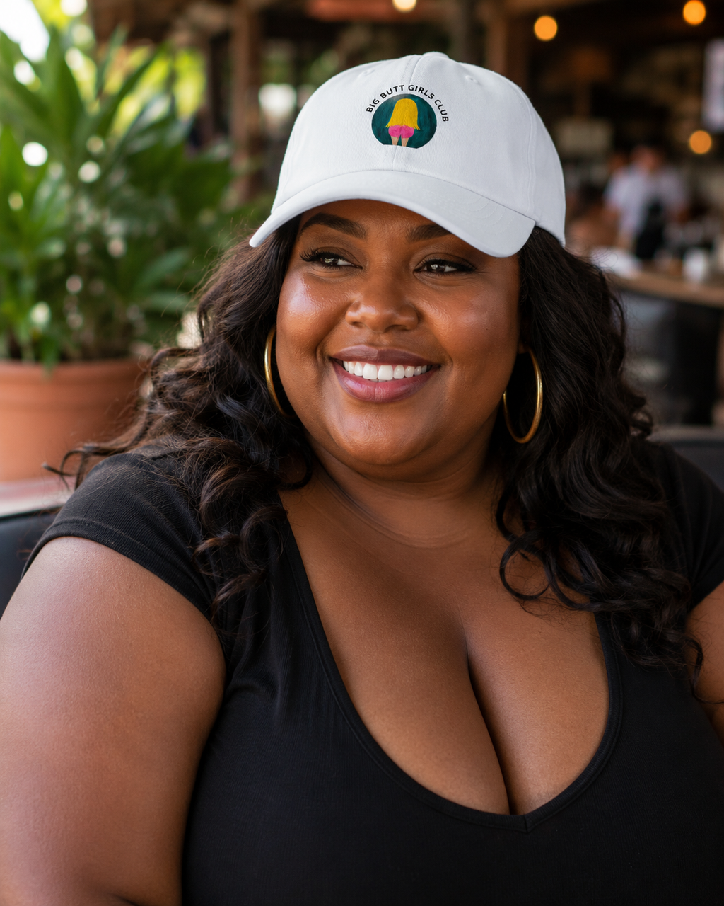 Woman wearing a white cap with a logo in an outdoor setting