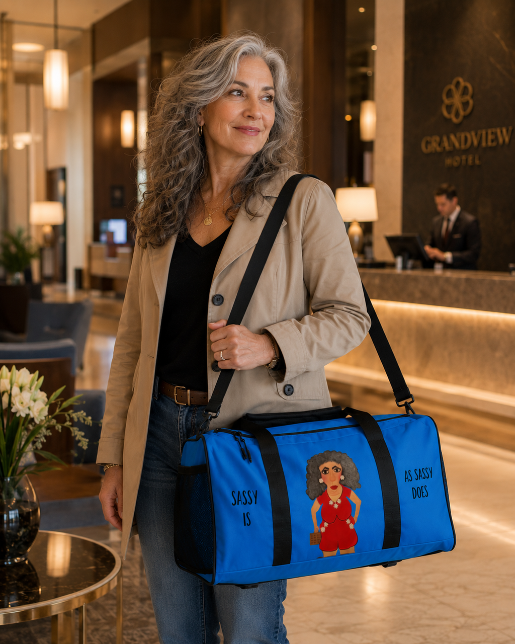 Woman holding a blue duffel bag with a character design in a hotel lobby.