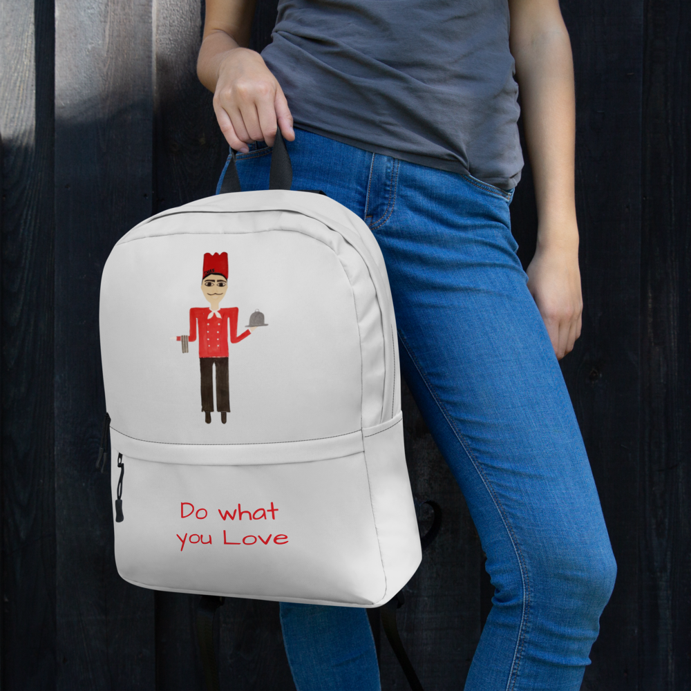 Person wearing a white backpack with a design and text, standing against a dark background