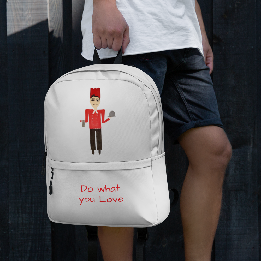 White backpack with angel design held by a person against a dark background