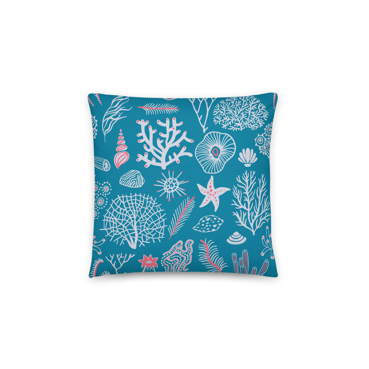 A square throw pillow featuring an all-over ocean-themed pattern of white and pink sea corals, starfish, and seashells on a vibrant teal blue background, shown against a plain white studio backdrop.