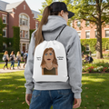 Person wearing a gray hoodie with a white drawstring bag featuring an illustration and text.