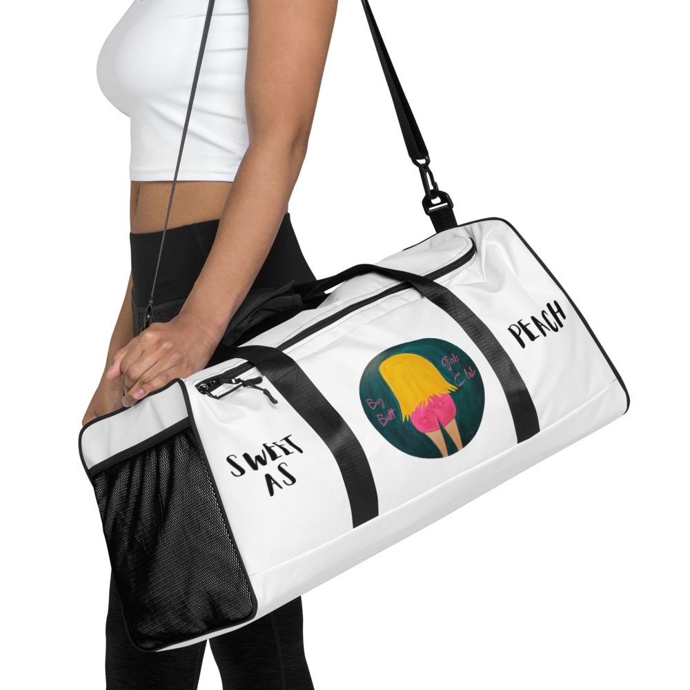 White duffel bag with colorful design and text held by a person on a white background