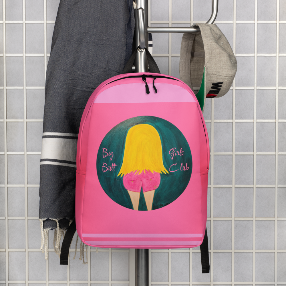 Pink backpack with graphic design hanging on a rack against a tiled wall.