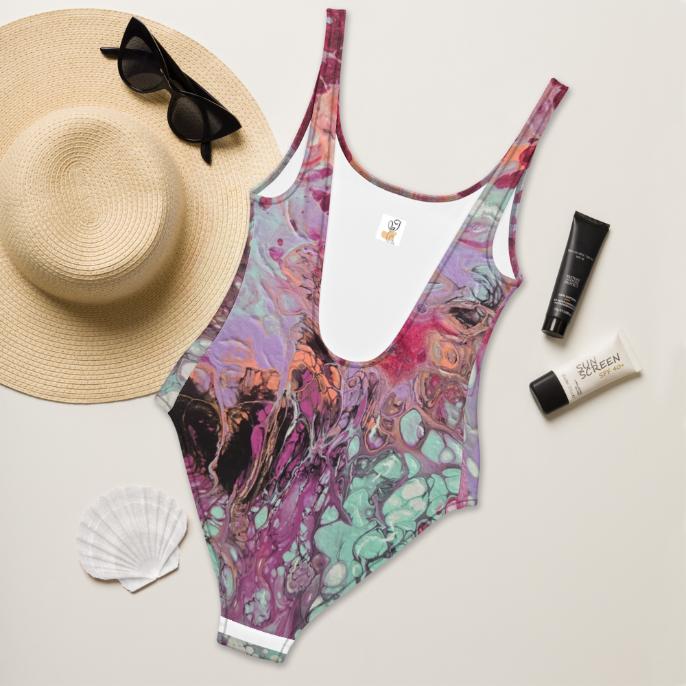 Colorful swimsuit with sun hat, sunglasses, and sunscreen on a light background