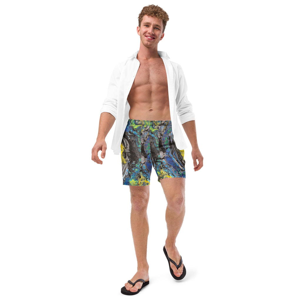 Man wearing colorful swim shorts and a white shirt on a white background