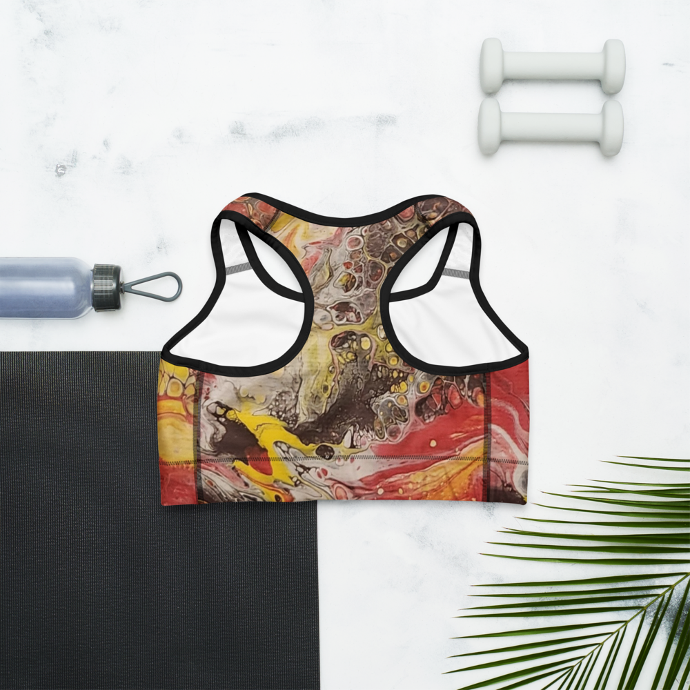 Colorful sports bra with a graphic design on a white marble surface with a yoga mat, water bottle, and dumbbells.