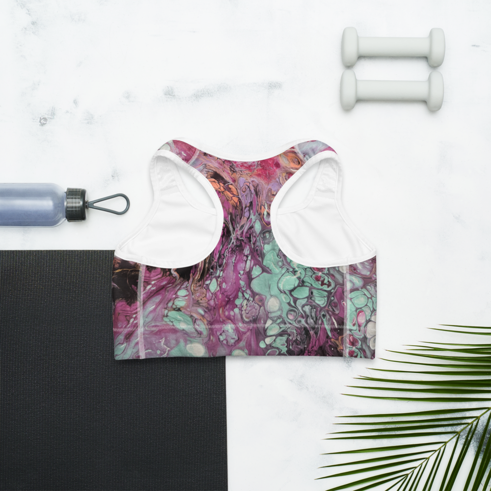 Colorful sports bra with floral pattern on a white background with fitness items.