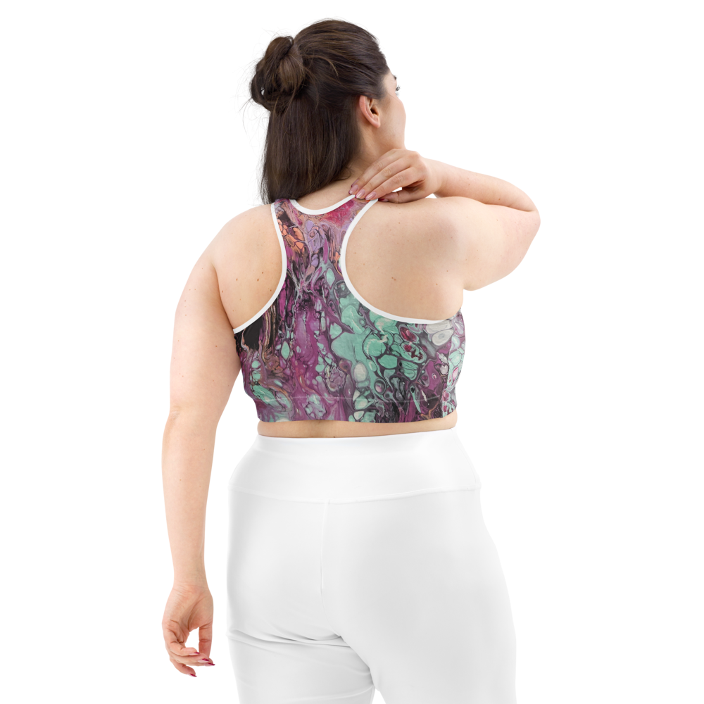 Woman wearing a colorful sports bra and white leggings on a white background