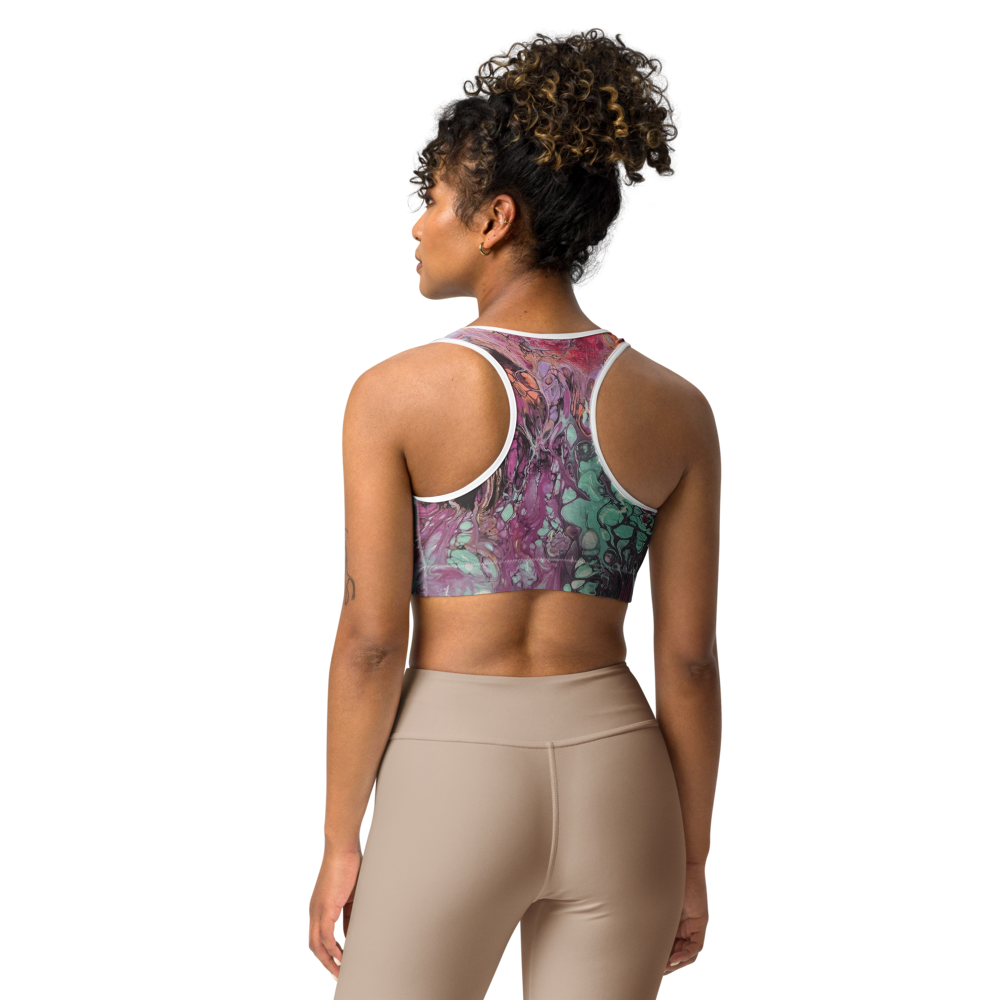 Woman wearing a patterned sports bra and beige leggings on a white background
