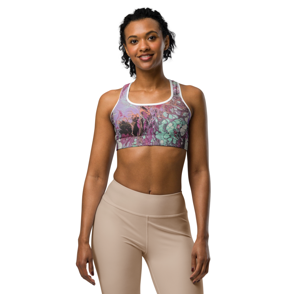 Woman wearing a colorful sports bra and beige leggings on a white background