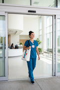 image of a female nurse carrying a tote bag with a whimsical character nurse as she exits a hospital lobby