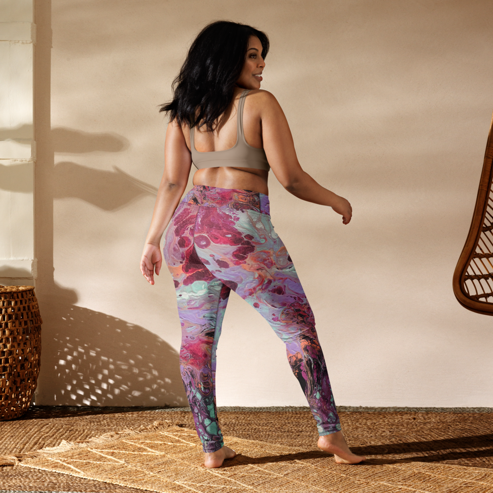 Woman wearing colorful leggings and a sports bra in a warm-toned room.