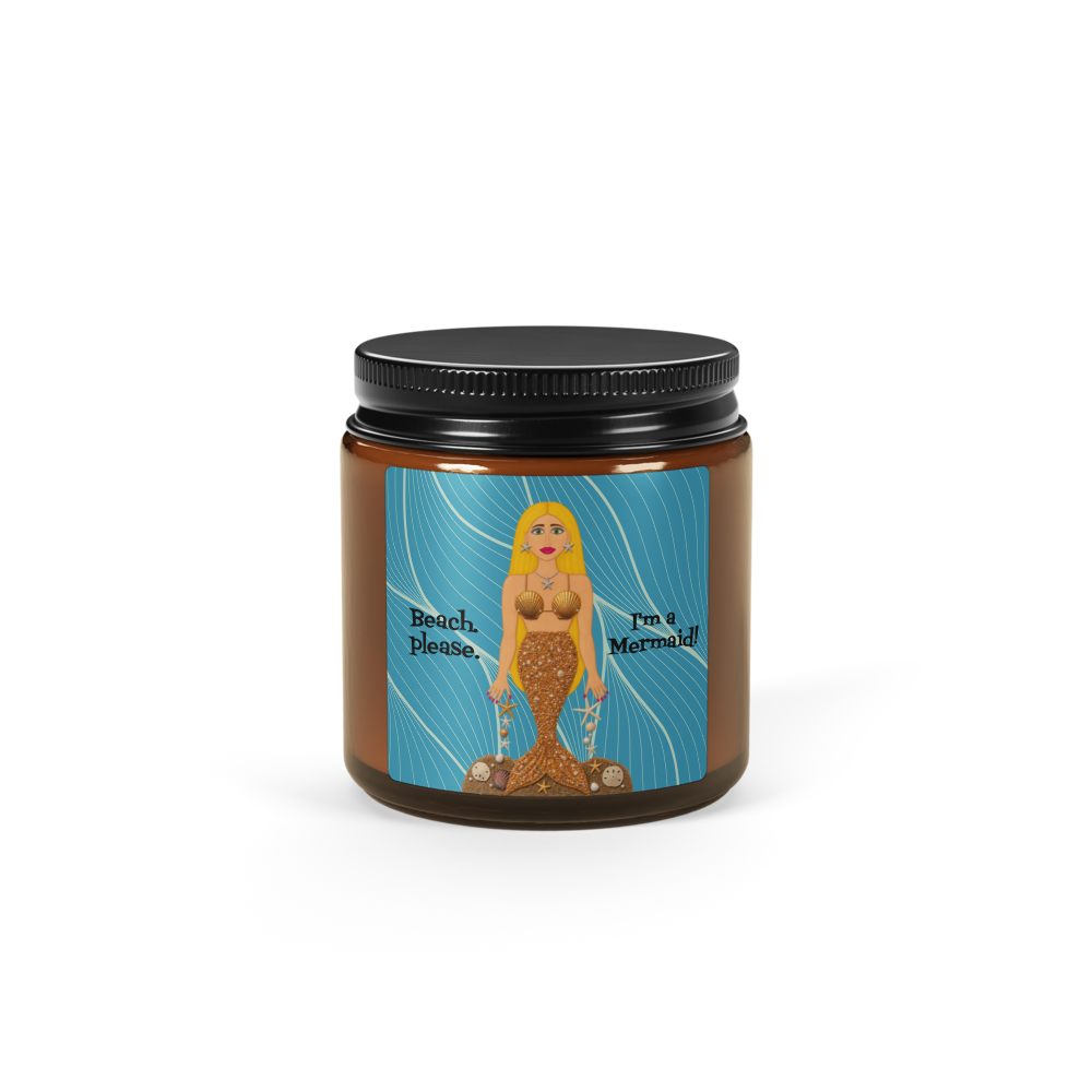 An amber glass jar candle with a black metal lid and a colorful mermaid-themed label, shown on a plain white background.