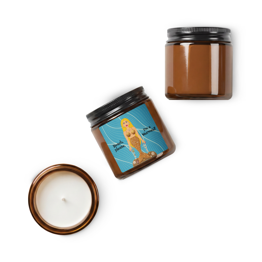 An amber glass jar candle shown in three views on a white background: one closed with a black lid and one visible wax surface, one open showing white wax, and one angled with a colorful mermaid illustration label reading 'My favorite thing.'.