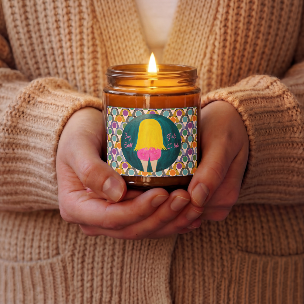 Person holding a lit candle with a colorful label featuring a cartoon character.