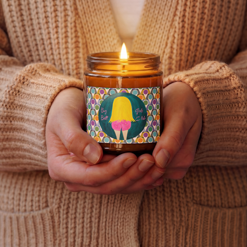 Person holding a lit candle with a colorful label featuring a cartoon character.