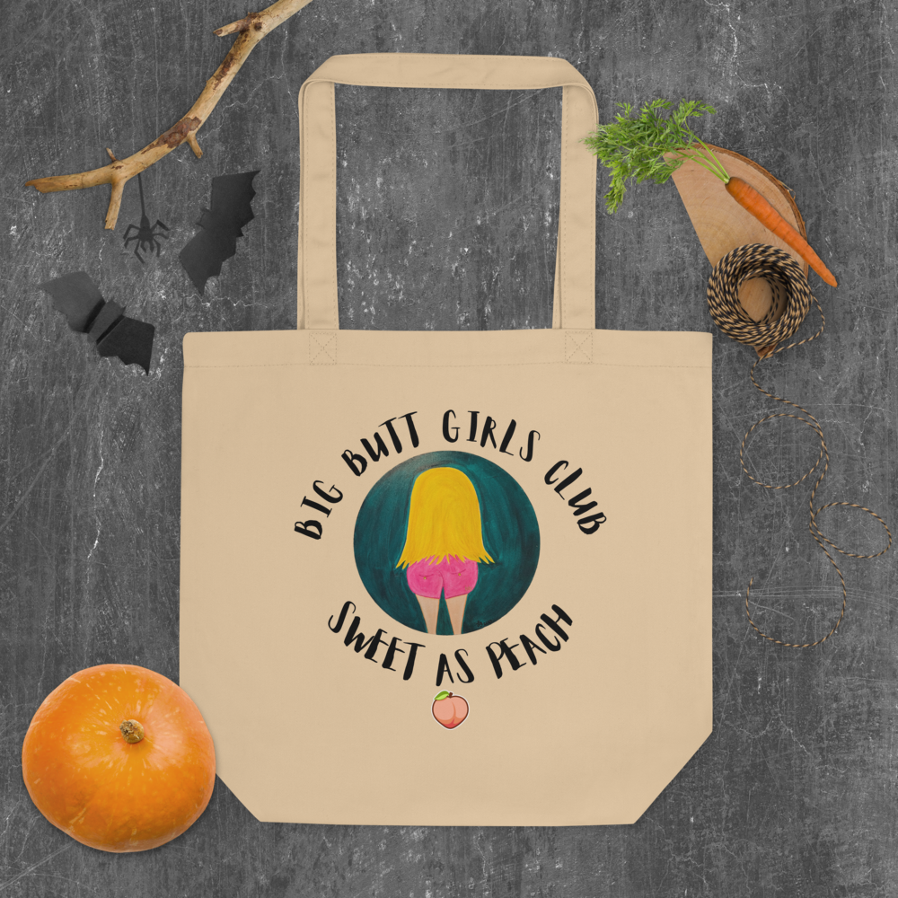 Beige tote bag with 'Big Butt Girls Club Sweet as Peach' design on a textured surface.