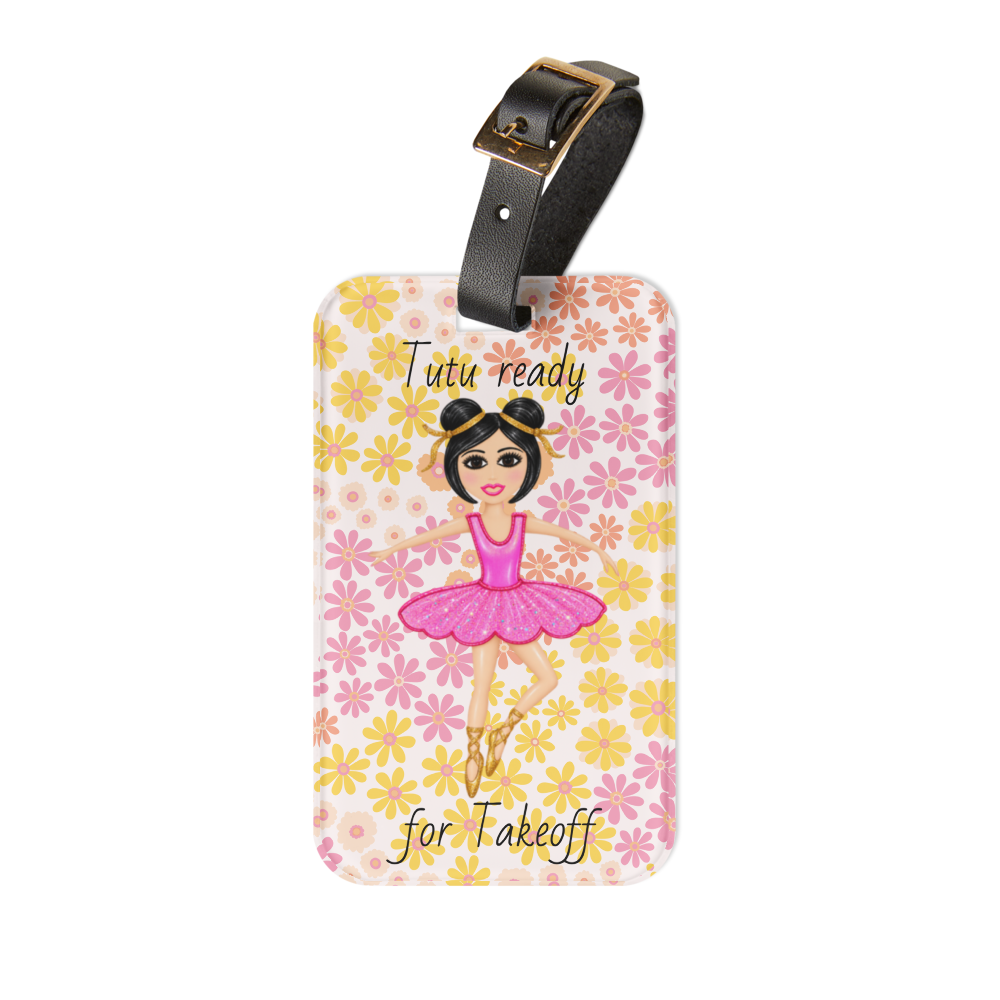 A personalized luggage tag featuring a cartoon ballerina on a pink and yellow floral pattern background, with the text 'Tutu ready for Takeoff' and a black leather strap with a gold buckle.