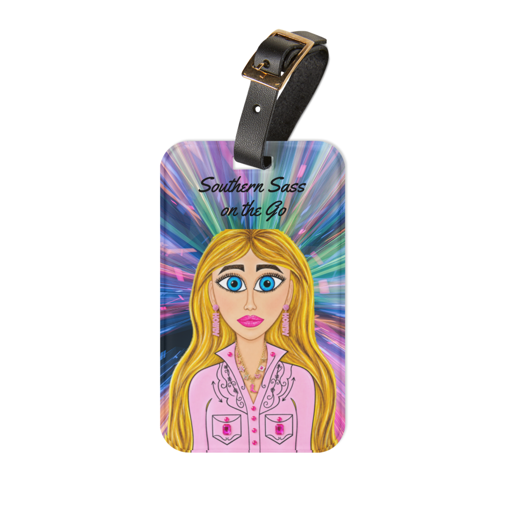 A rectangular luggage tag with a black strap and gold-tone buckle, featuring a colorful illustrated portrait of a blonde woman with blue eyes and the text 'Southern Sass on the Go' on a white background.