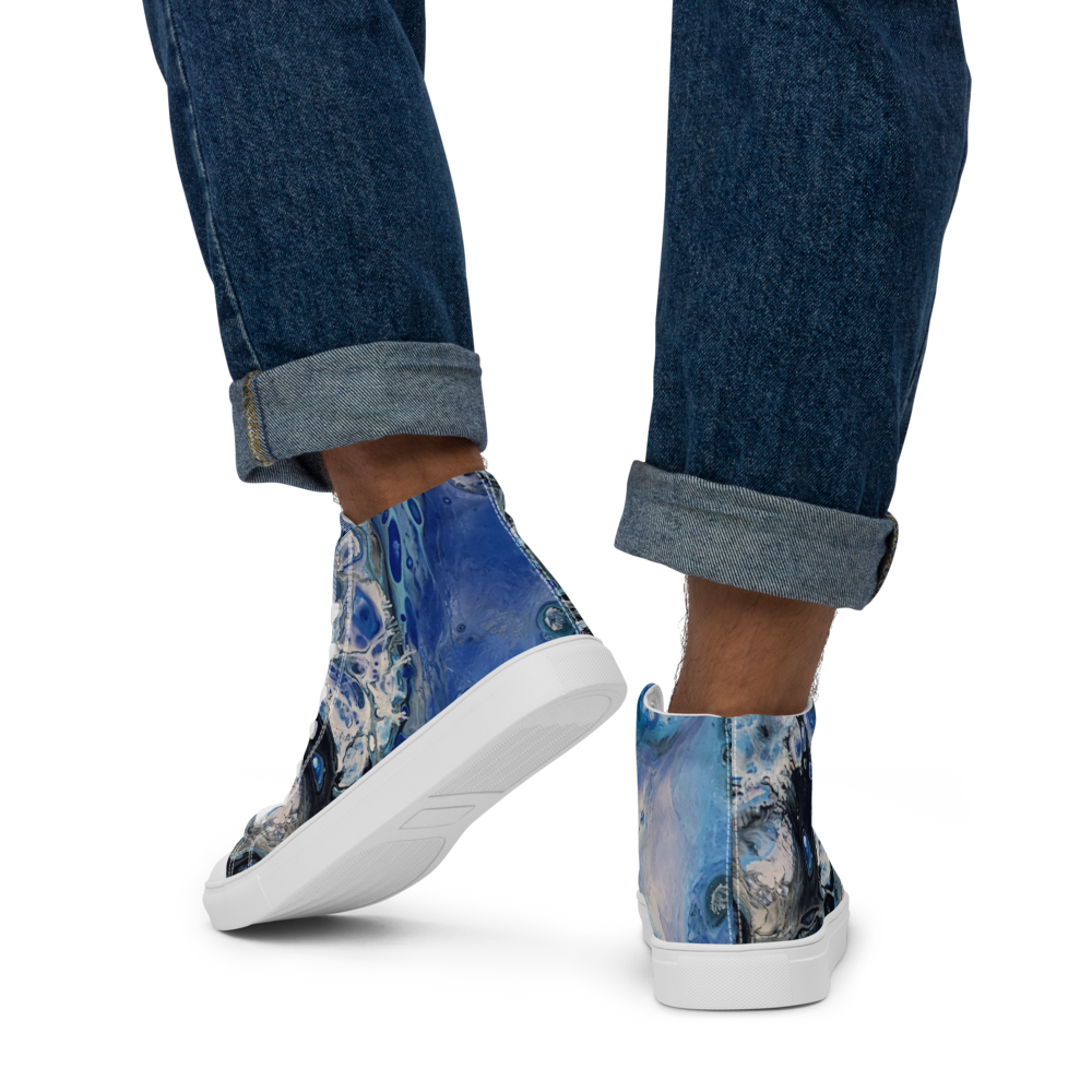 Blue patterned sneakers worn with rolled-up jeans on a white background