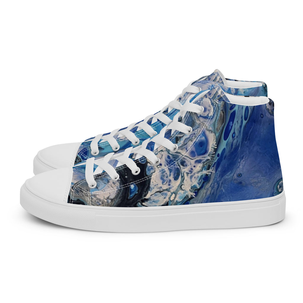 Blue patterned sneakers worn with rolled-up jeans on a white background