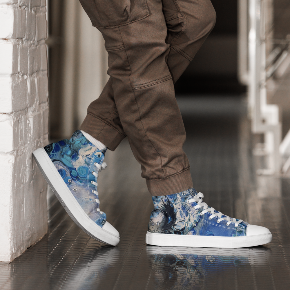 Person wearing blue floral high-top sneakers with white soles on a reflective floor.
