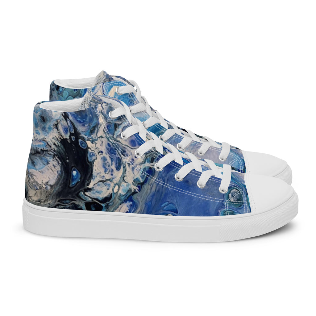 Blue patterned sneakers worn with rolled-up jeans on a white background