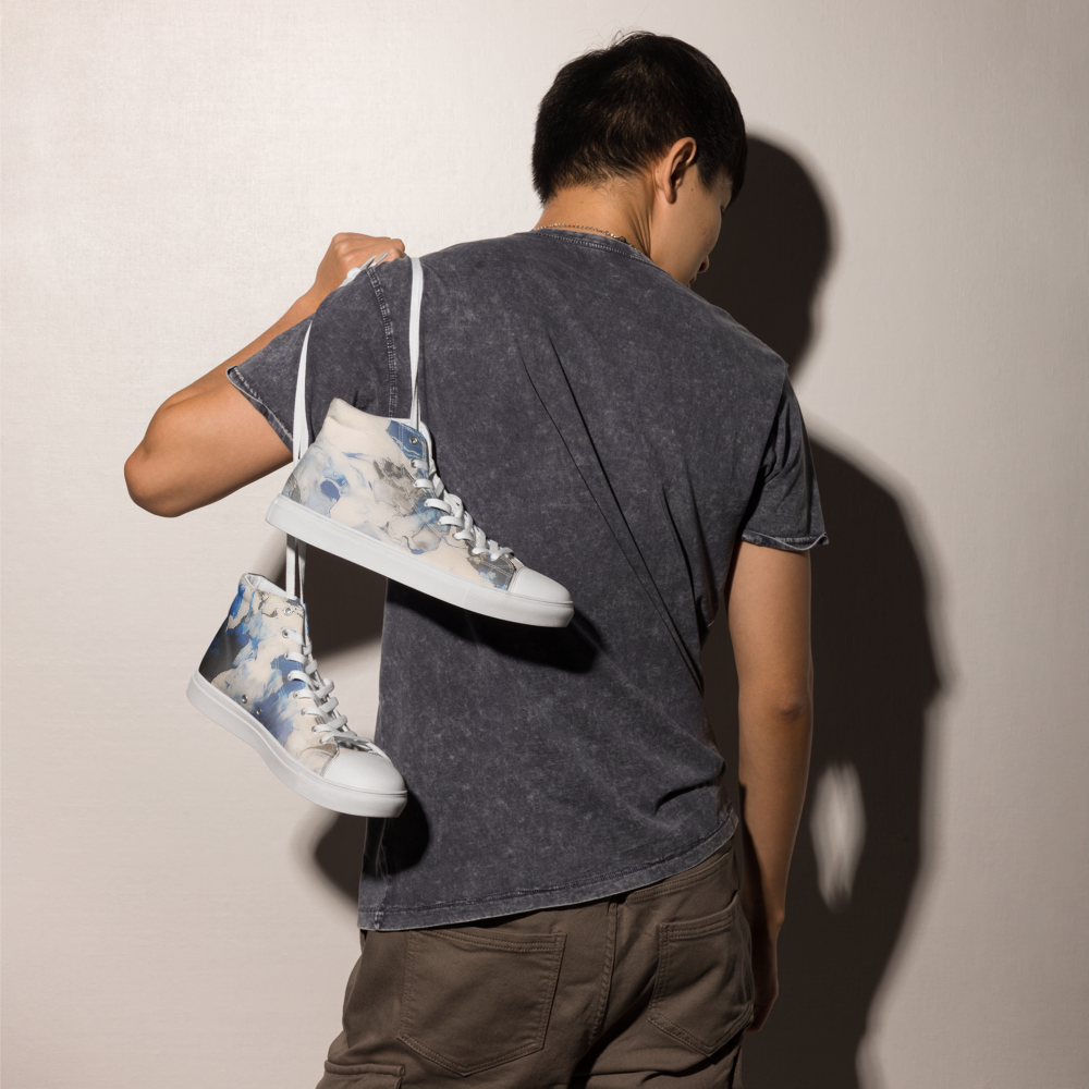 Person holding a pair of high-top sneakers against a plain background