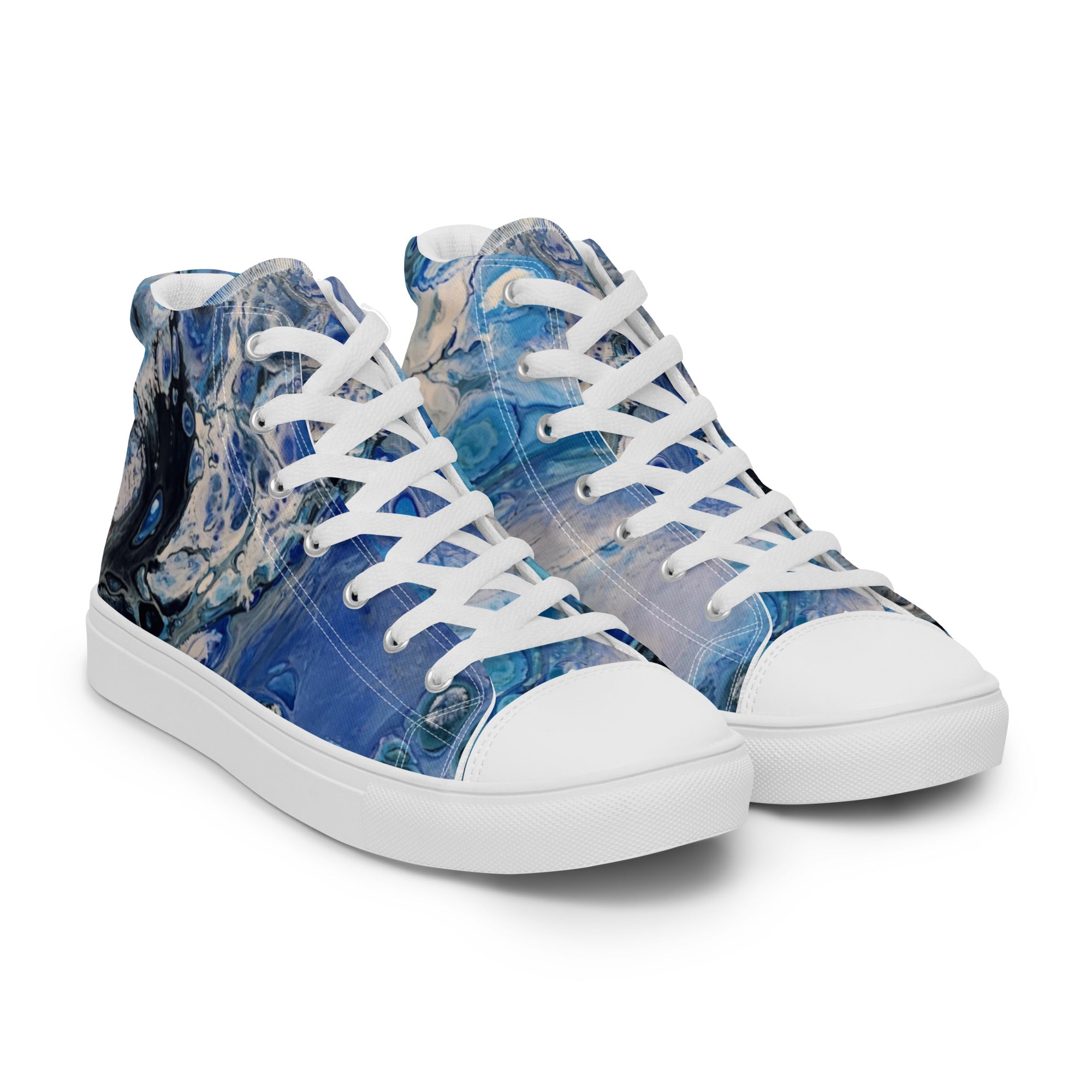 Blue patterned sneakers worn with rolled-up jeans on a white background