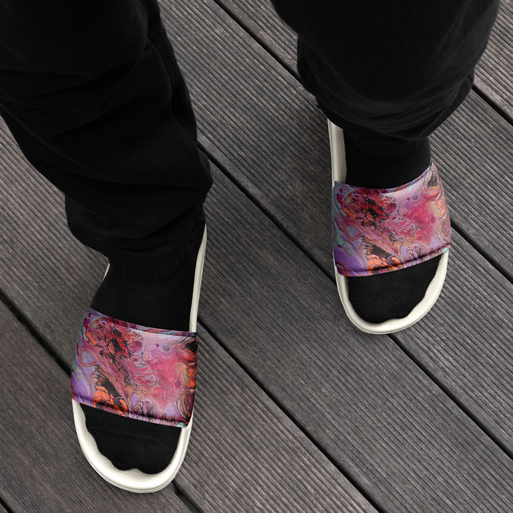 Person wearing colorful sandals with black pants on a white background