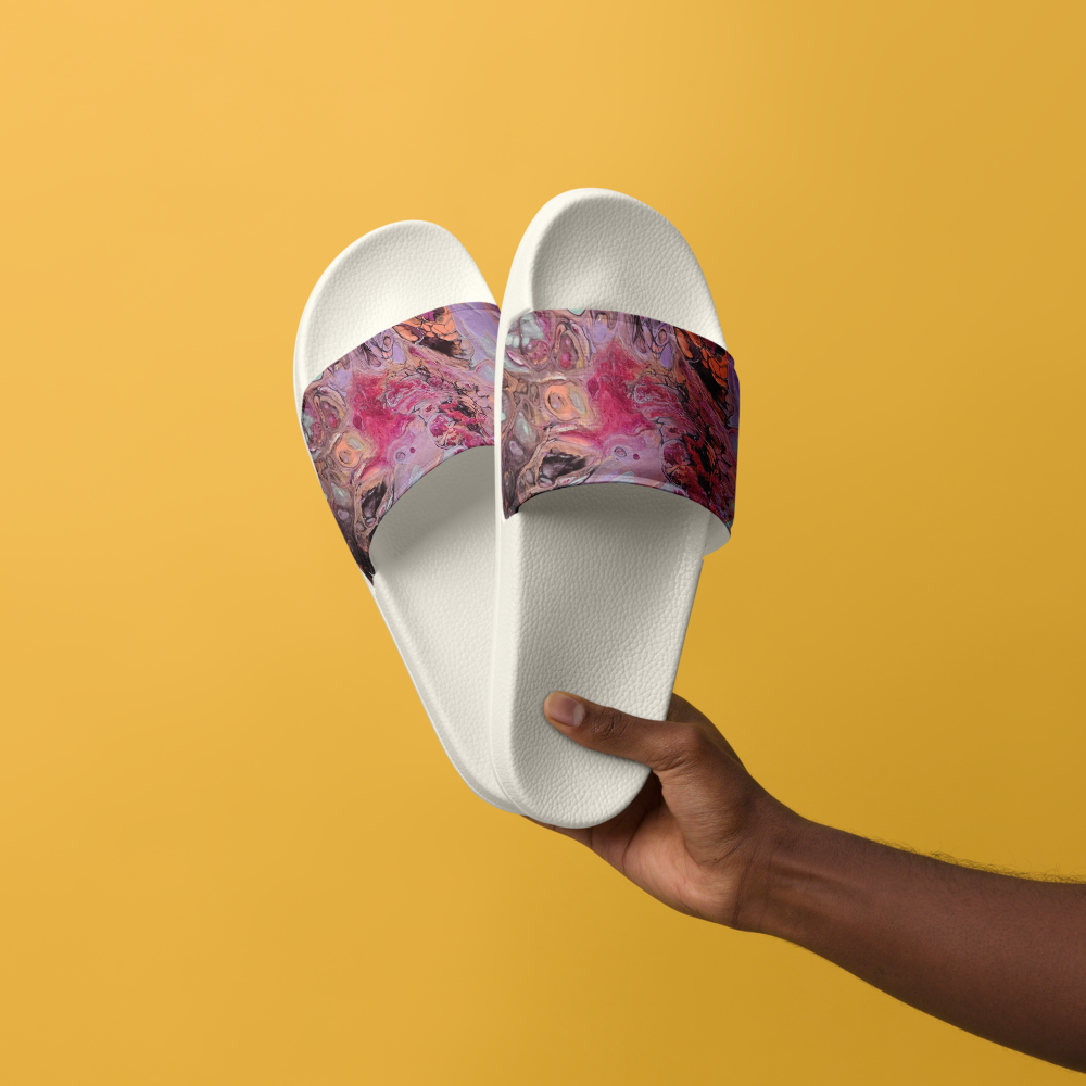 White slides with colorful straps held by a hand against a yellow background