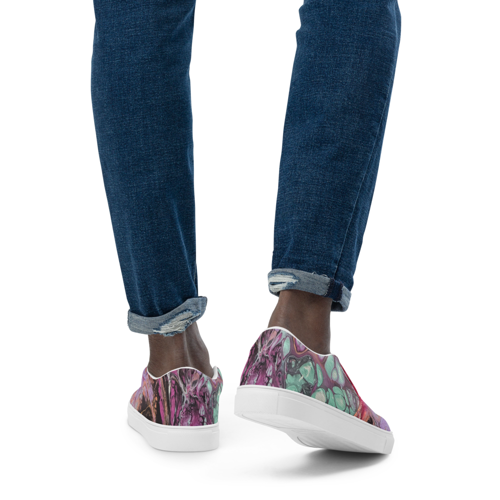 Multicolored slip-on sneakers worn with blue jeans on a white background