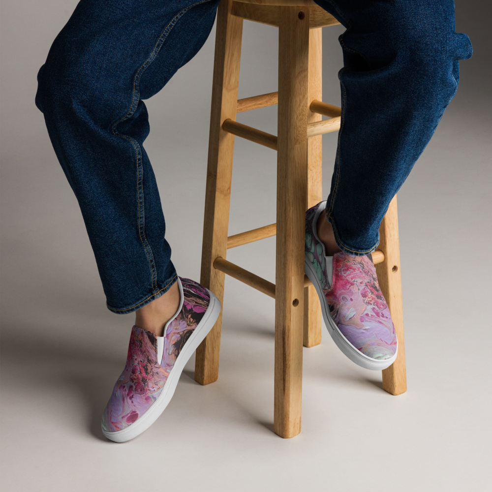 Person wearing floral slip-on shoes on a wooden stool with a neutral background