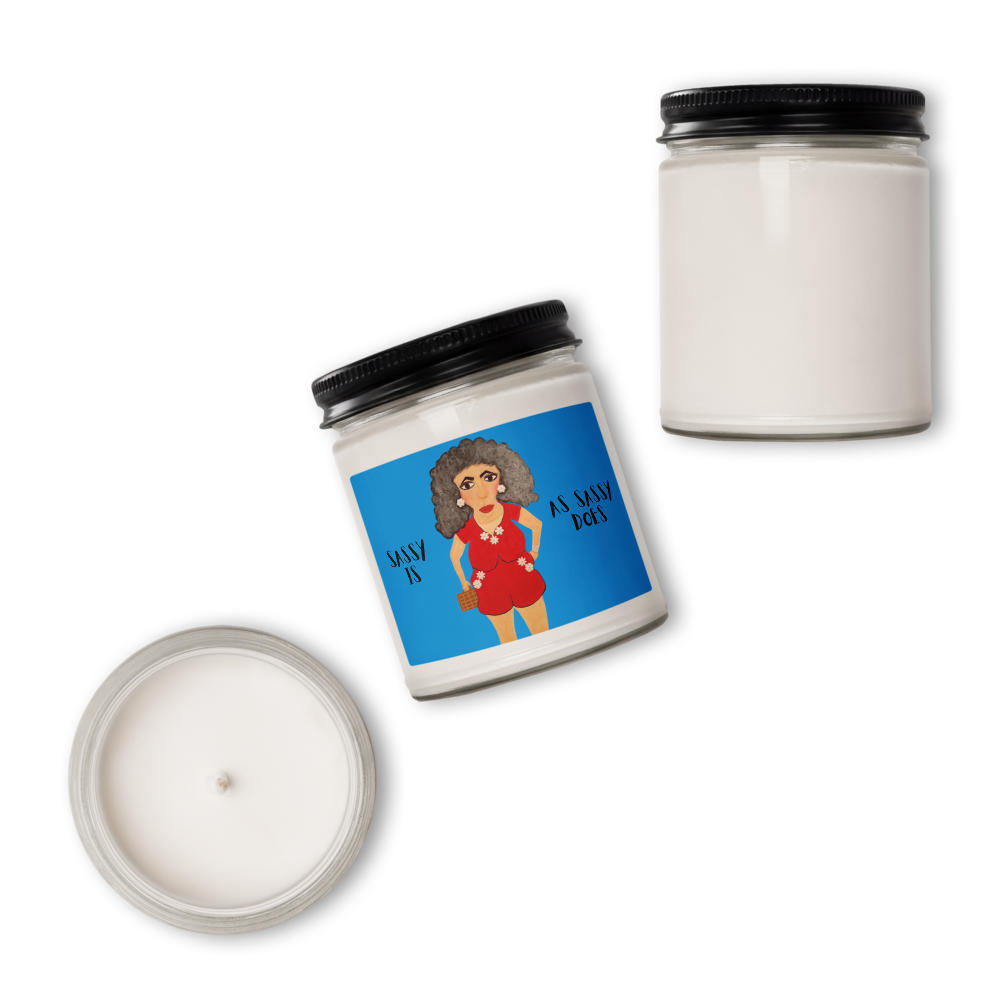 A white soy wax candle in a clear glass jar with a black metal lid, shown from multiple angles on a white background. One view shows the jar closed with a bright blue label featuring a cartoon illustration of a woman with an afro and the text 'AS MAY AS YOU'.