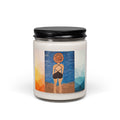 A white wax candle in a clear glass jar with a black metal lid, featuring a colorful graphic label of a woman from behind on a beach with a blue sky and geometric side panels.