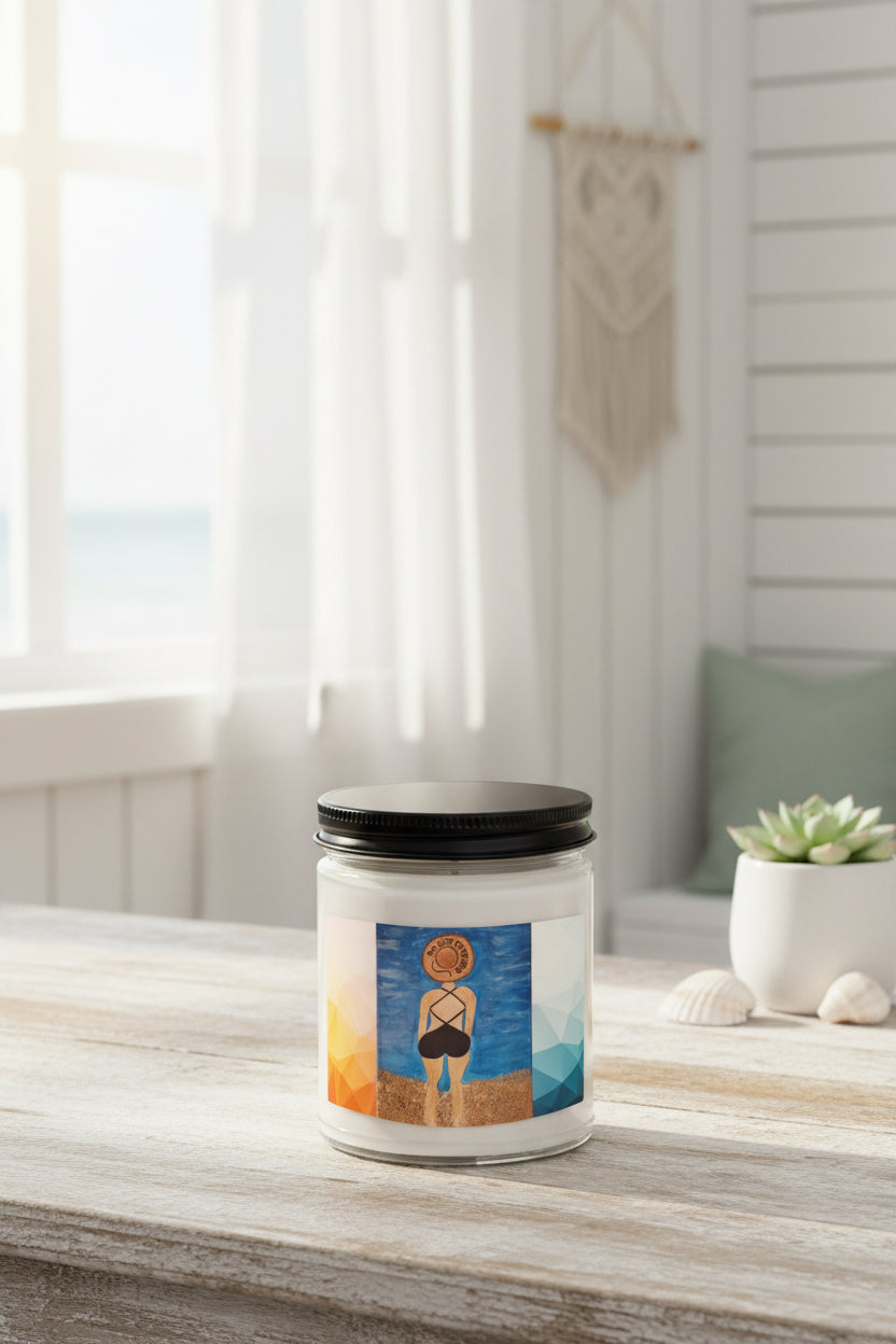 A white glass jar candle with a black screw-on lid, featuring a colorful beach-themed label illustration of a woman from behind on a sandy shore under a blue sky.