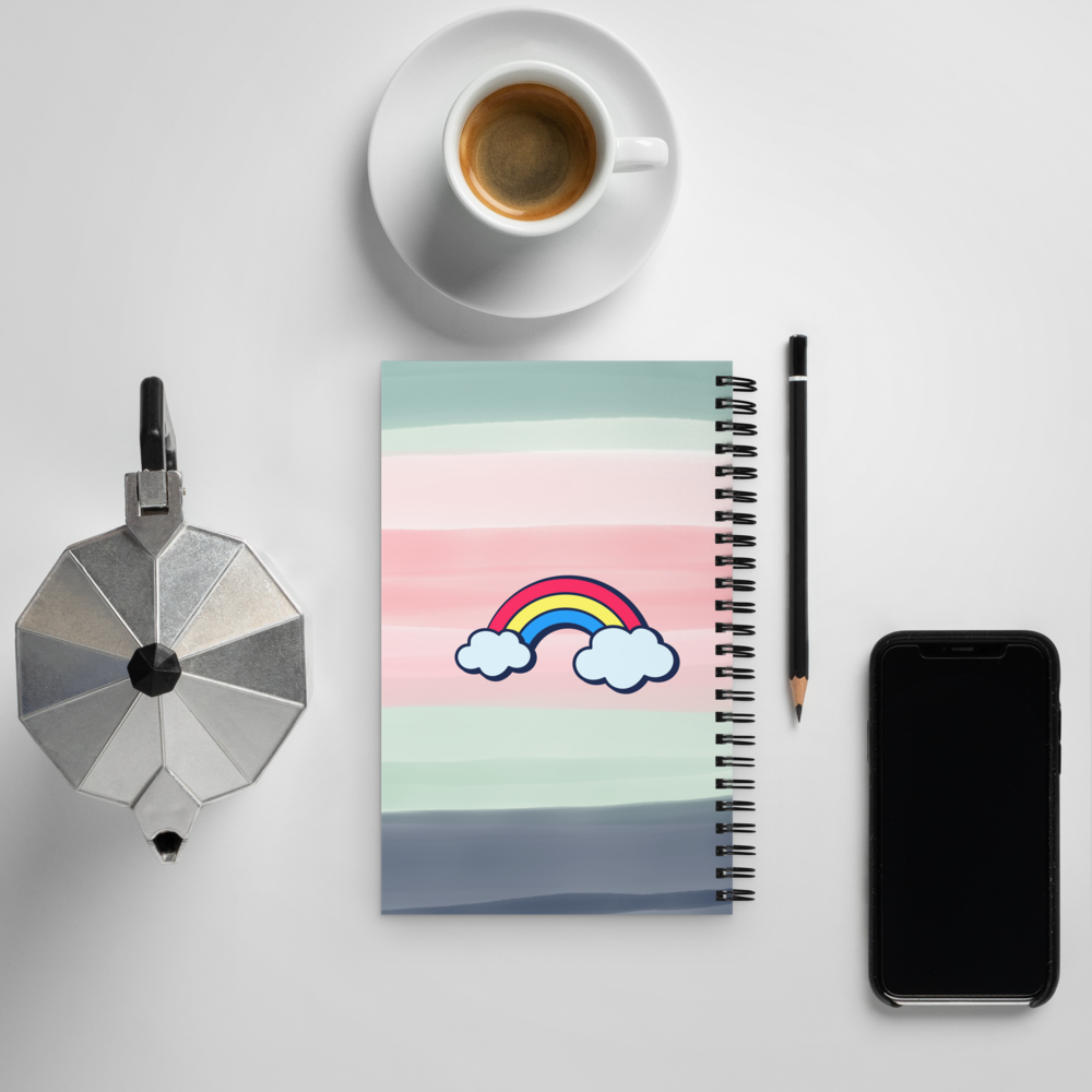 Notebook with a rainbow design, coffee cup, pencil, and smartphone on a light gray background