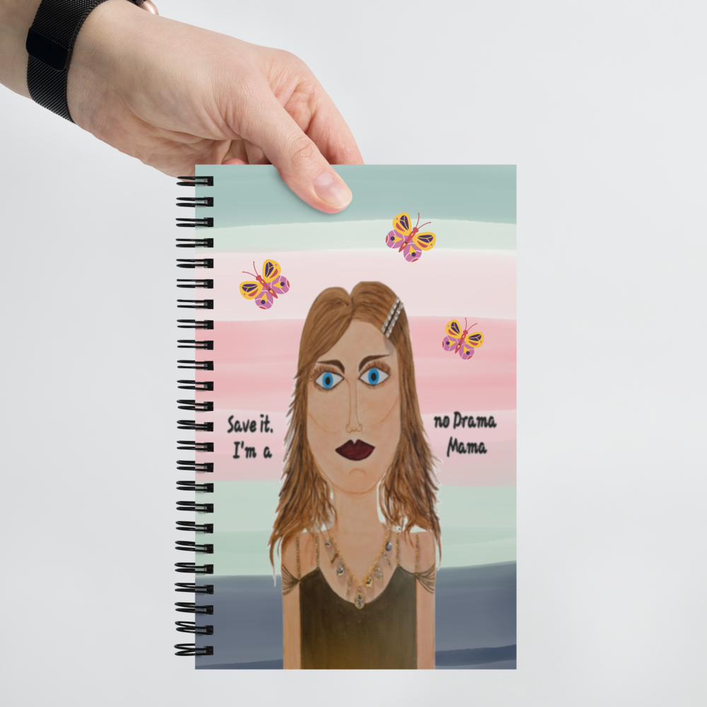 Notebook with a colorful cover featuring a stylized illustration of a woman and butterflies, held by a hand.