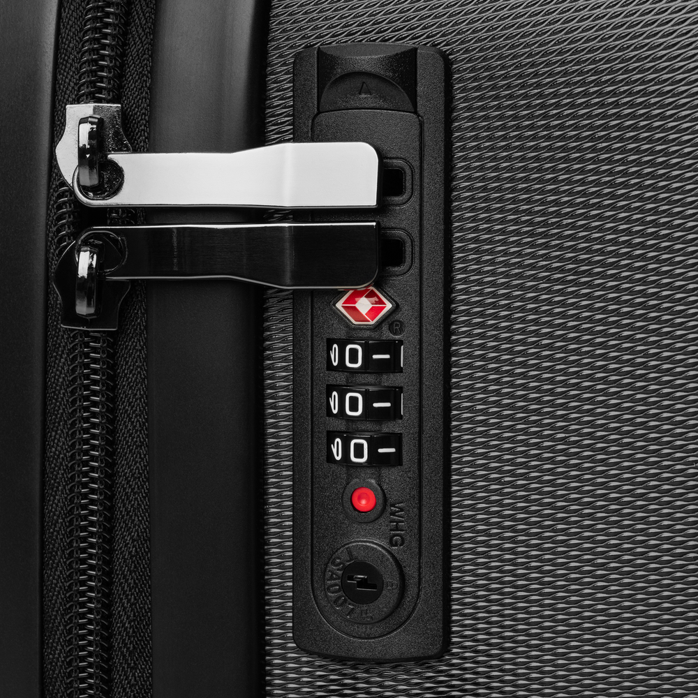 Close-up of a suitcase handle and lock mechanism on a textured surface