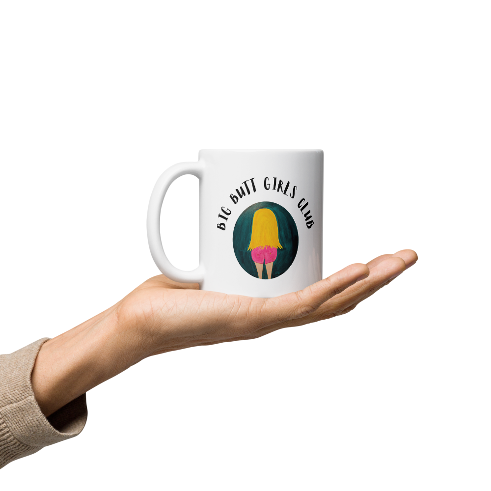 Mug with 'Big D**t Girls Club' design held in a hand on a white background