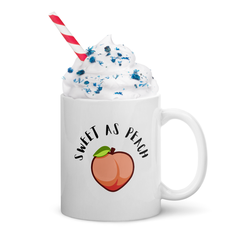 White mug with 'Sweet as Peach' design, filled with a dessert-like drink.