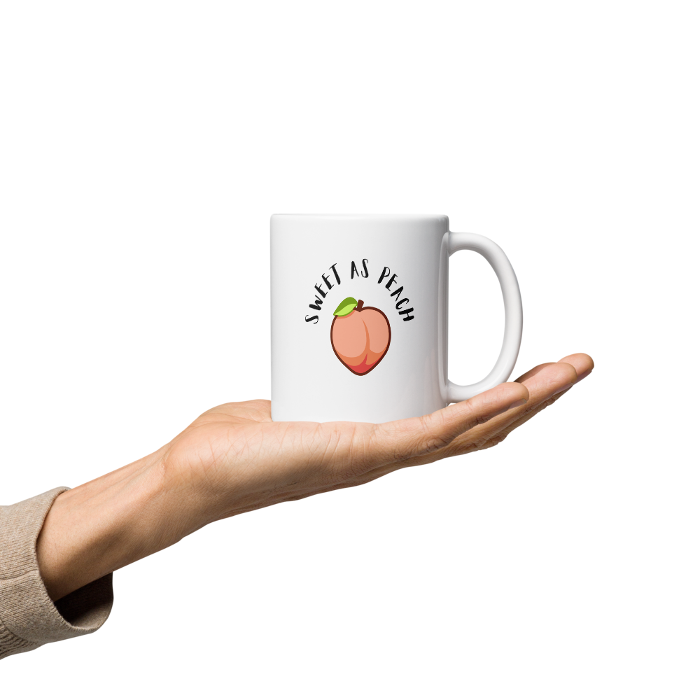 White mug with 'Feisty & Fabulous' text held in a hand on a white background