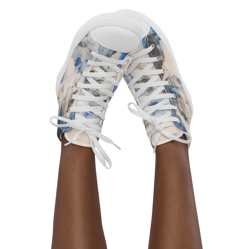 White sneakers with blue floral pattern worn by a person on a white background
