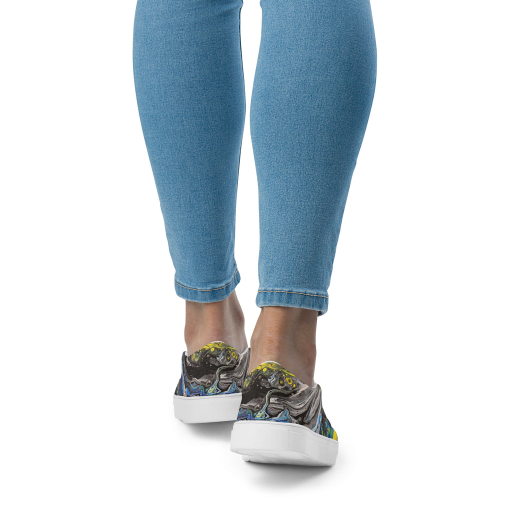 Person wearing blue jeans and colorful sneakers on a white background